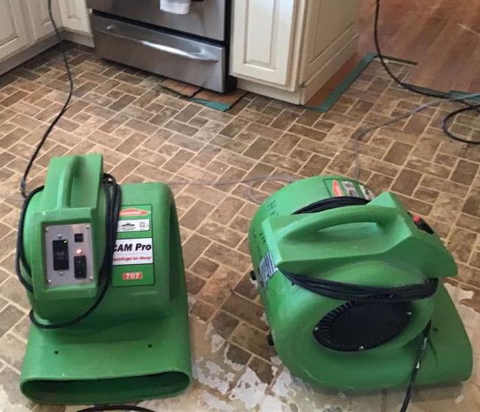 Drying equipment on kitchen floor after water loss.
