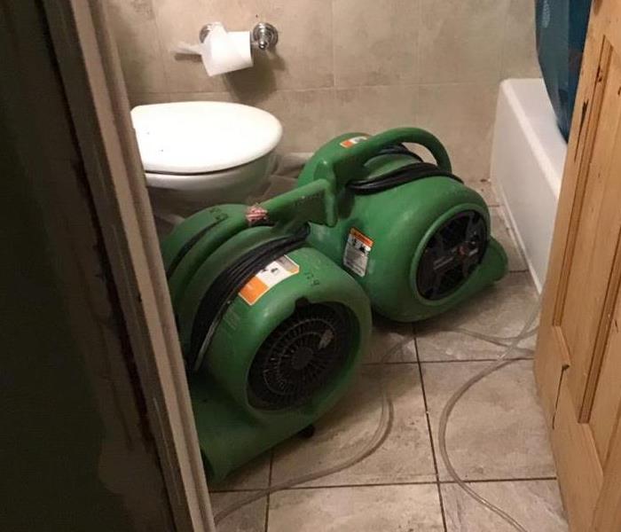 Green drying equipment set up in a bathroom.